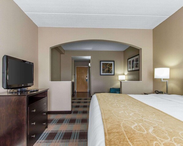 Ein Hotelzimmer mit Bett, Fernseher, Schreibtisch und Lampe.