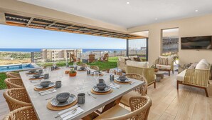 Ein Essbereich mit Tisch für sechs Personen, mit Blick auf Pool und Meer.