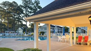 A covered outdoor area with a pool, white chairs, and a gazebo. - Golf Course Views & Pool: Myrtle Beach Retreat (Myrtle Beach)