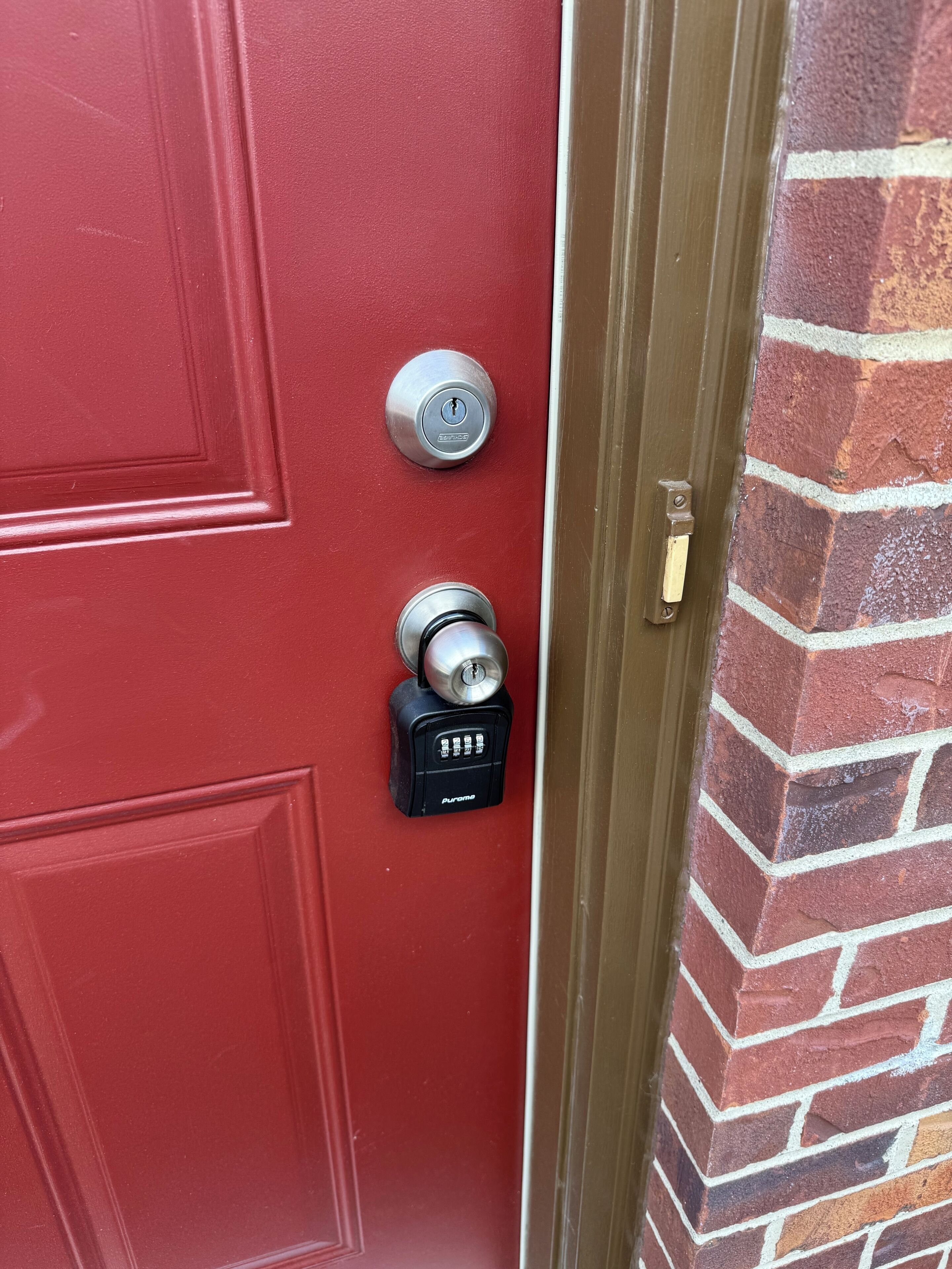 A red door with a keyhole and a doorbell.