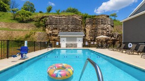 A swimming pool with a lifeguard chair, lounge chairs, and a rock wall backdrop. - Perfectly located for Branson fun, No step access, 2 pools and modern finishes. (Branson)
