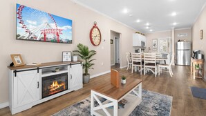 A modern living room with a fireplace, a dining area, and a kitchen. - Perfectly located for Branson fun, No step access, 2 pools and modern finishes. (Branson)
