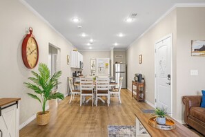 A modern kitchen with white cabinets, a dining table, and a clock on the wall. - Perfectly located for Branson fun, No step access, 2 pools and modern finishes. (Branson)