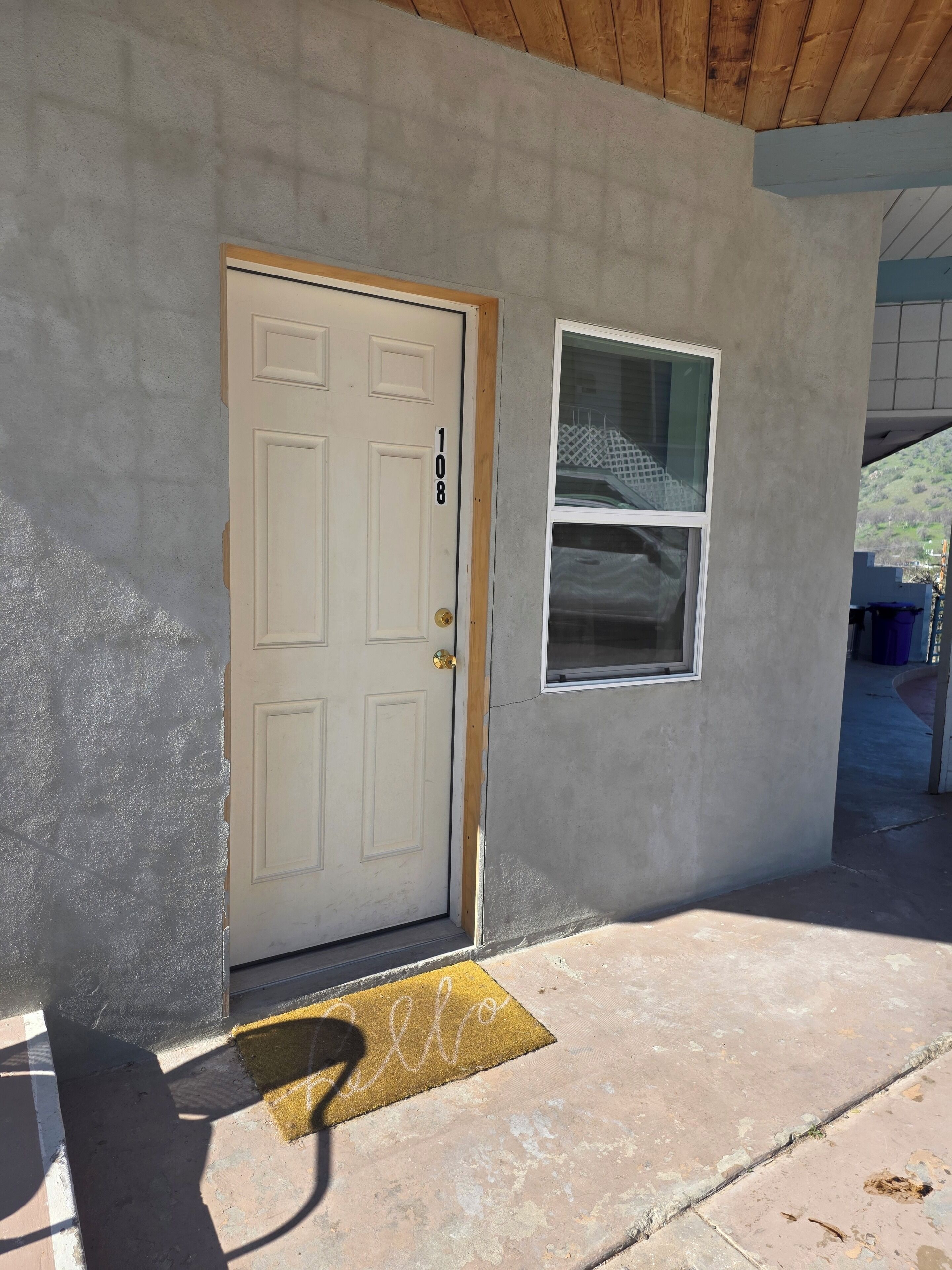 A house with a white door, a window, and a doormat.