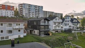 A residential area with modern houses, including a two-story house with a balcony and a detached house with a garage. - Stunning apartment in Tromsø with WiFi (Tromsø)