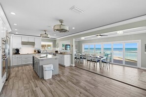 A modern kitchen with a large island, a dining area with a view, and a spacious living area.