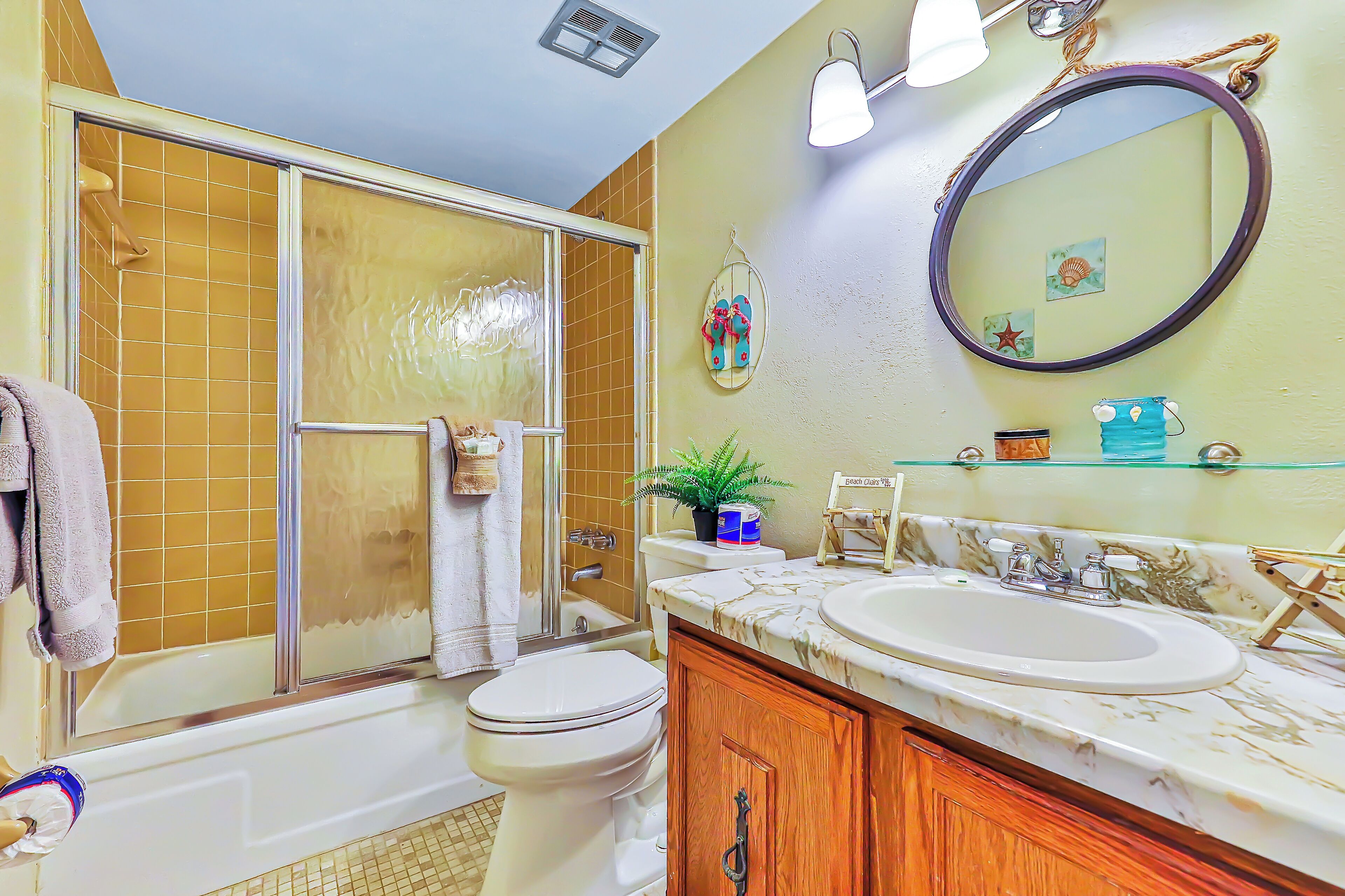 A bathroom with a bathtub, toilet, sink, and a large mirror.