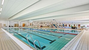 Piscina interior com pistas demarcadas, posto de salva-vidas e sala de vestiários.