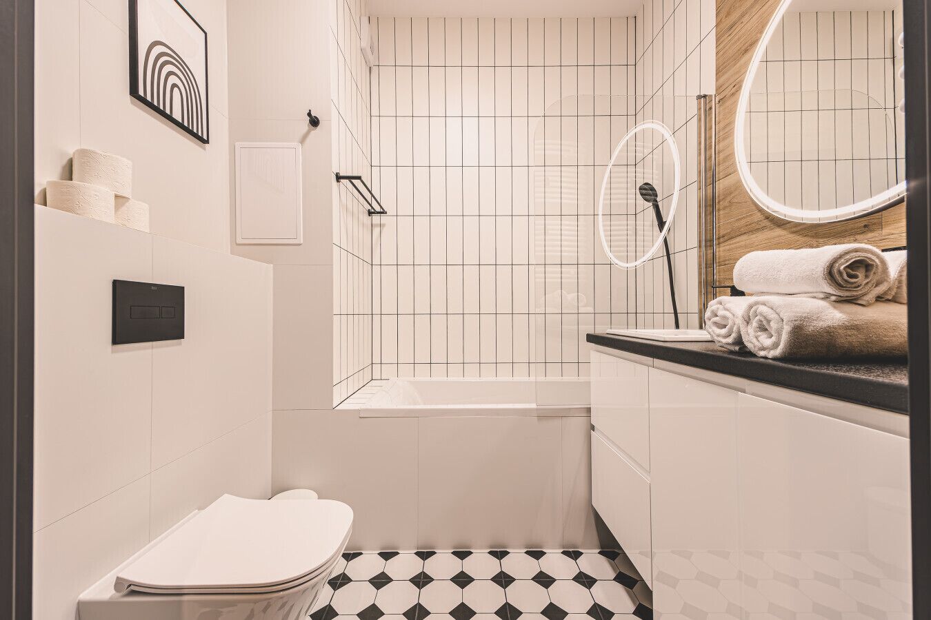A modern bathroom with a bathtub, toilet, and sink.