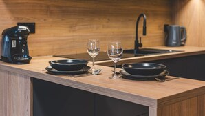 A kitchen counter with two black bowls, two wine glasses, and a coffee maker. - Calma Wanna Balkon Studio Centrum (Bydgoszcz)