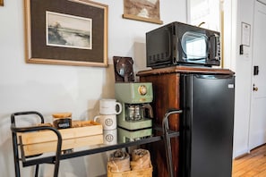 Una cocina equipada con cafetera, microondas y refrigerador.