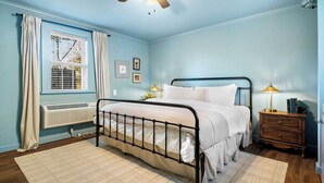 A bedroom with a bed, a nightstand, a lamp, a window with curtains, and a ceiling fan. - Falling Water Suite on Lookout Mountain (Lookout Mountain)