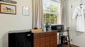 Eine Küchenzeile mit Kaffeemaschine, Mikrowelle und Stauraum.