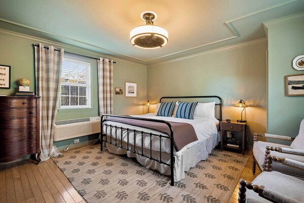 A bedroom with a bed, bedside table, lamp, and a window with curtains. - Hiwassee Suite on Lookout Mountain (Lookout Mountain)