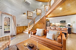 A cozy interior with a staircase, a wooden dining area, and a kitchen with modern appliances. - Farm Silo with Mountain Views & Hot Tub (Chattanooga)