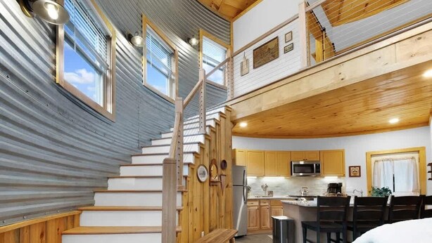 A multi-level interior with a staircase, kitchen, dining area, and a loft space. - Cozy Ridge Silo - Sleeps 6 with Private Hot Tub (Chattanooga)
