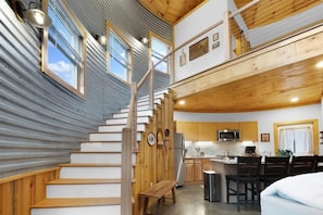 A multi-level interior with a staircase, kitchen, dining area, and a loft space. - Cozy Ridge Silo - Sleeps 6 with Private Hot Tub (Chattanooga)