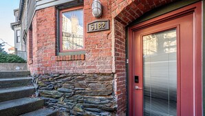 A brick building with a stone foundation, a red door, and a number plate reading 5182. - Modern Heritage Apartment in the Heart of Halifax (Halifax)