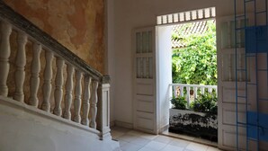Una scala con balaustre bianche che conduce a una porta con un pannello di vetro.