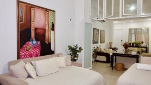Un'ampia camera da letto con un grande letto, una zona relax con divano e un tavolo da pranzo.