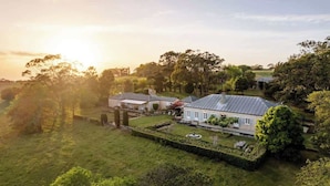 A large estate with multiple buildings, expansive lawns, and mature trees. - One-of-a-Kind French Farm Stay in Kiama Hinterland (Jerrara)