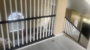 Una scala con ringhiera bianca e parete color crema.