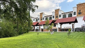 Un hotel con varias construcciones, cada una con techo de tejas rojas y detalles de piedra.