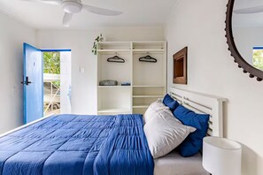 A bedroom with a bed, a wardrobe, a ceiling fan, and a view of the outdoors. - Self contained studio near the boat club with deck (Yorkeys Knob)