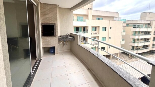 A balcony with a brick wall, a sink, and a TV. - Beautiful apartment located on Bombas Beach 🐶️ Sleeps up to 8 people (Bombinhas)