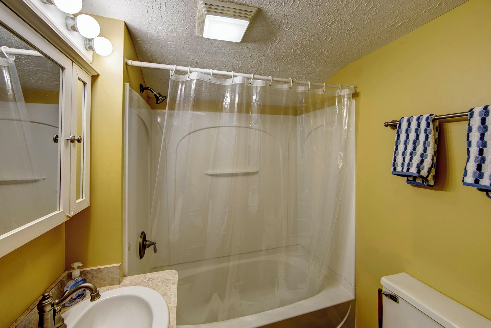Une salle de bain avec une douche, un lavabo et des toilettes.