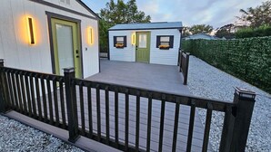 Un bâtiment à deux étages doté d’une terrasse en bois et d’une rambarde noire.