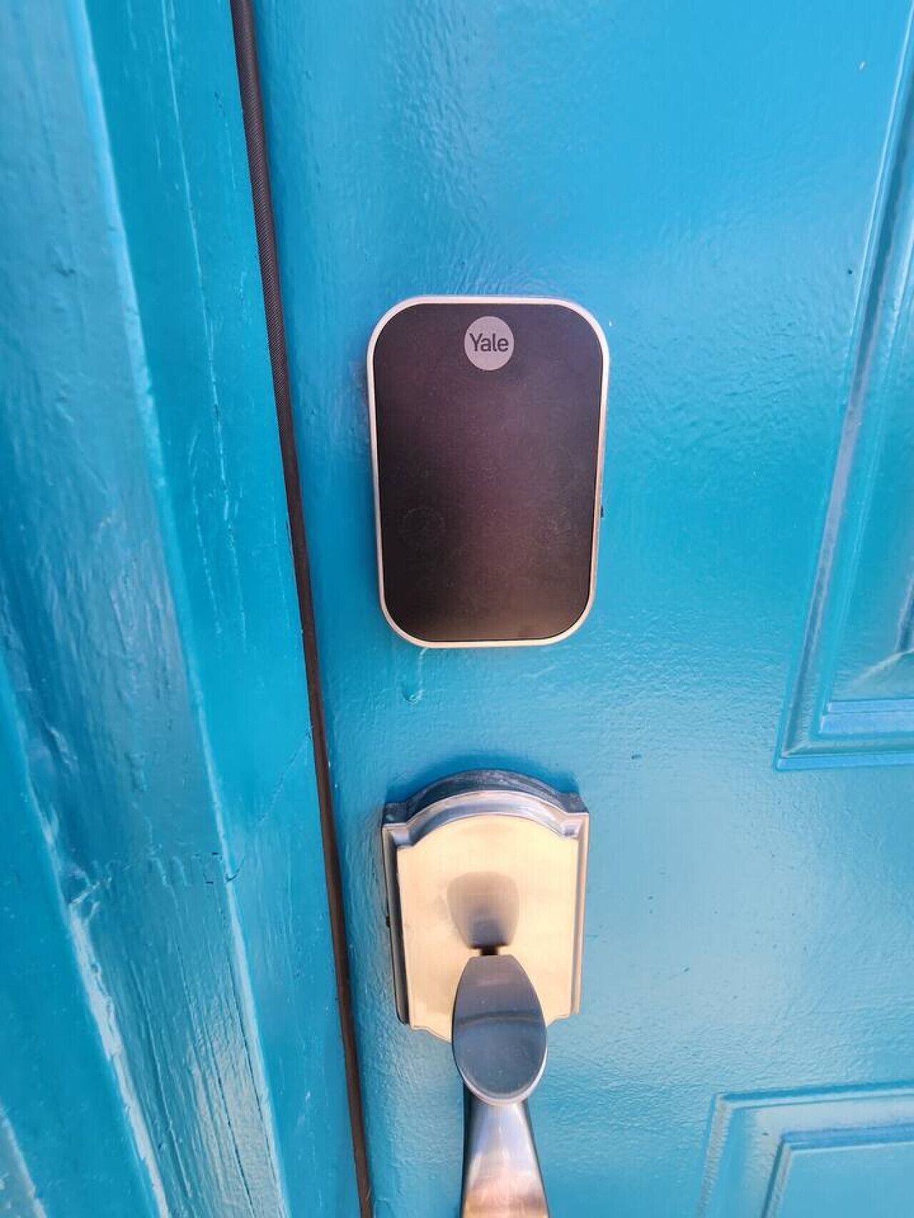 A blue door with a Yale deadbolt lock and a keyhole.