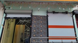 Um edifício de vários andares com fachada, persianas fechadas e uma motocicleta estacionada em frente.
