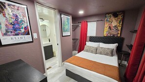 Ein Schlafzimmer mit Bett, Schreibtisch und Bildern an den Wänden.