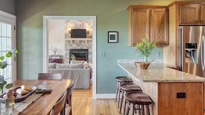 A modern kitchen with granite countertops, wooden cabinets, and a built-in stainless steel refrigerator. - Hot Tub, Deck w/ Breathtaking Mountain Views (Swannanoa)