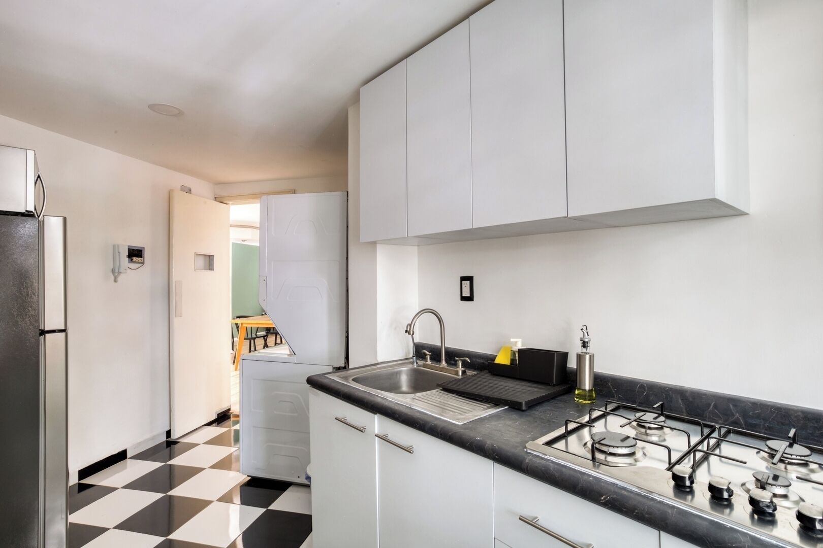 Een koelkast, een magnetron, een kookplaat, kookgerei, borden en bestek