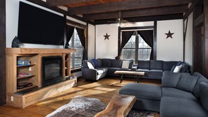 Un salon moderne avec une cheminée, des canapés modulaires et une table basse en bois.