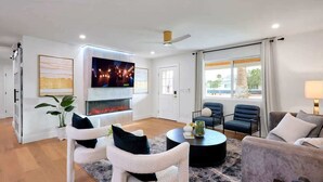 Een moderne woonkamer met een open haard, een flatscreen televisie en comfortabele zitplaatsen.