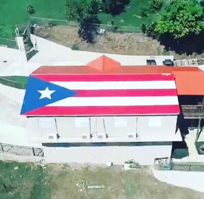 A building with a roof featuring a flag design. - Apartments Pepe's View - A (Bo. Piedras Blancas)