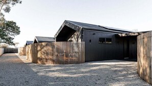 Een modern gebouw met een schuin dak en een grindpad.