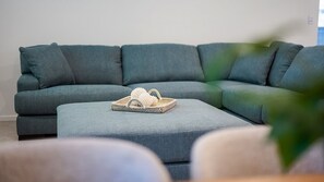 A modern living room with a grey sectional sofa and a woven basket on an ottoman. - Golden Tides - Mission Beach (Mission Beach)