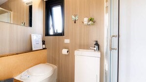 A modern bathroom with a toilet, sink, and shower. - Field and Fleece Farm Stay by Tiny Away (Levels Valley)