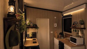 A compact kitchen with a wooden countertop, a microwave, and a hanging plant. - Field and Fleece Farm Stay by Tiny Away (Levels Valley)