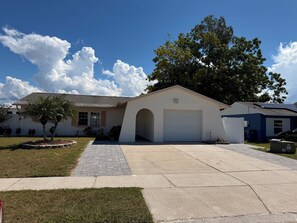 A residential house with a garage, a paved driveway, and a well-maintained lawn. - Sunny Oasis by Tarpon - Heated Pool, Hot Tub & Playground (Holiday)