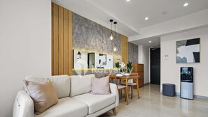 A modern living room with a sofa, dining table, and chairs. - Sorven by Kozystay - BSD (Pagedangan)