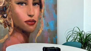 Un comedor moderno con una mesa redonda blanca, dos sillas y un par de prismáticos sobre la mesa.
