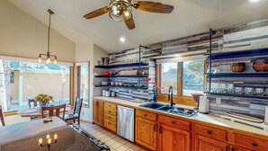 A modern kitchen with wooden cabinets, a built-in stove, and a window overlooking a backyard. - Work & Play! Spacious Lake-View Home in Greeley (Greeley)