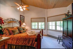 A bedroom with a bed, a nightstand, a dresser, a ceiling fan, and windows with blinds. - Top floor corner penthouse with heated floors.  Ski in/out to Elkhorn lift (Beaver Creek)