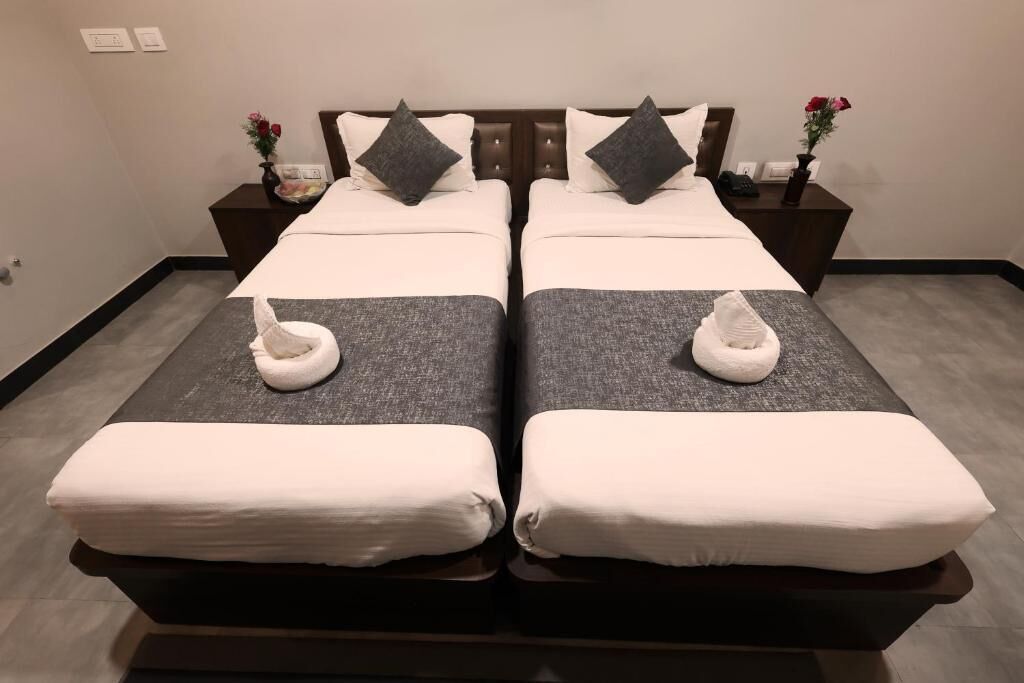 Ein Doppelbett mit zwei Nachttischen, auf jedem steht eine Blumenvase.