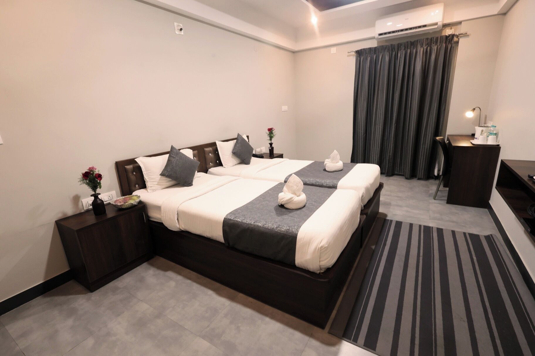 A hotel room with a large bed, a desk, and a chair.